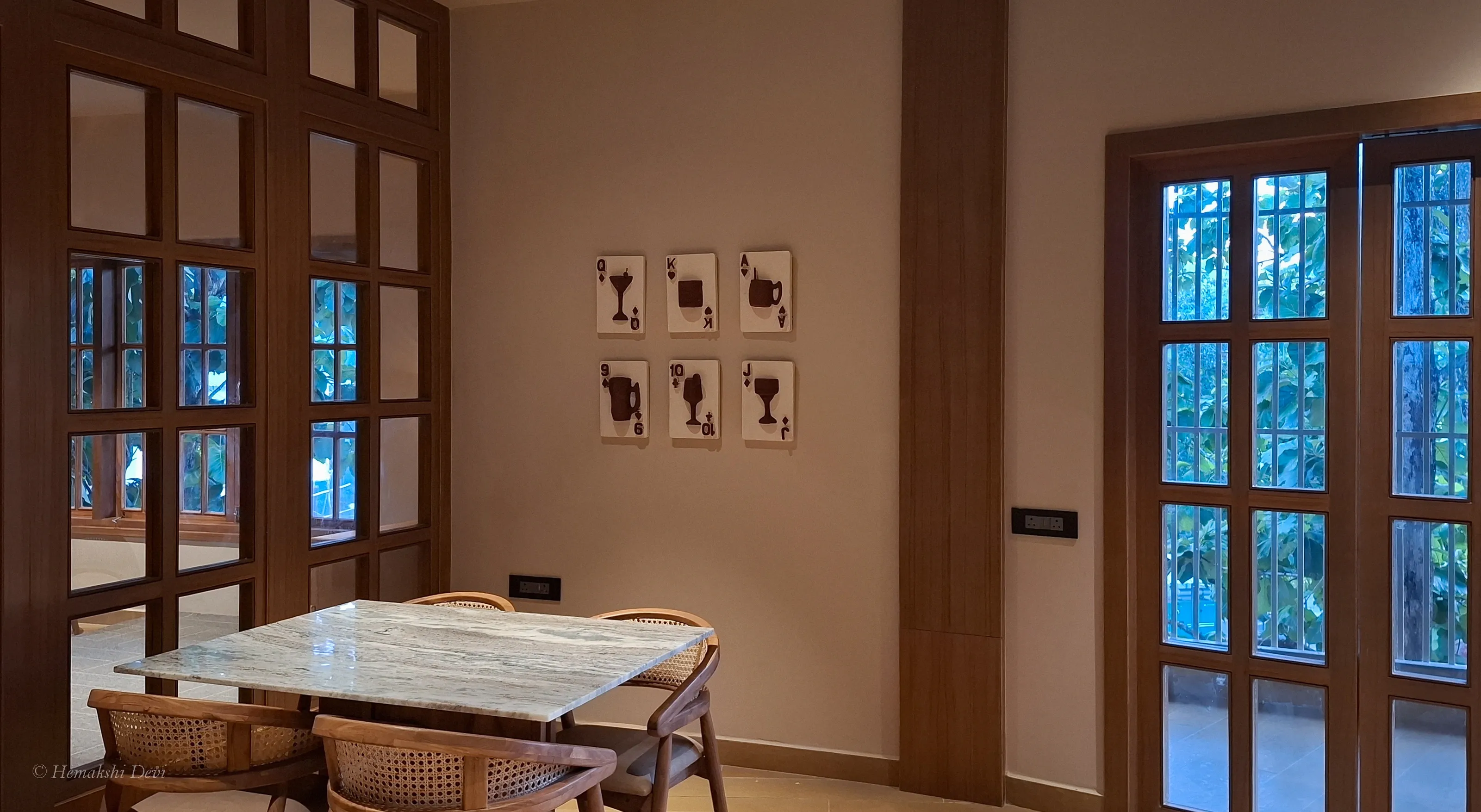 Six playing-card reliefs, suits redrawn as cocktail glasses and kettles, mounted on the Joha Brew bar wall